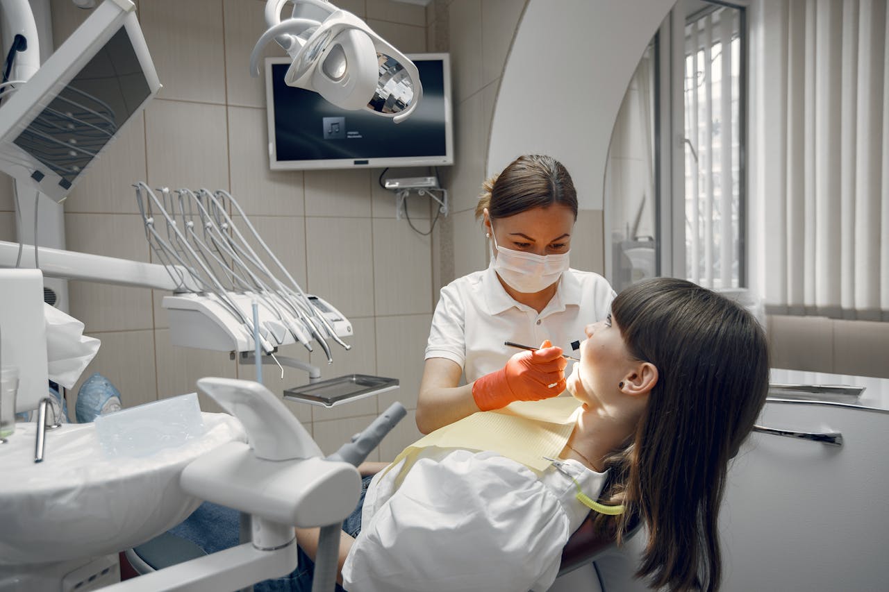 services-02 Dentist performing dental examination on female patient in modern clinic.