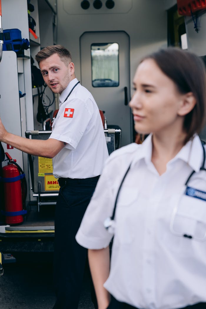 services-04 Two paramedics in uniform at an ambulance ready for emergency service.